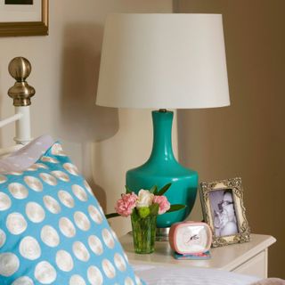 bedroom corner with vintage style clock lamp on bedside table