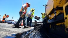 Workers repave a road in Alhambra, California, in 2021.