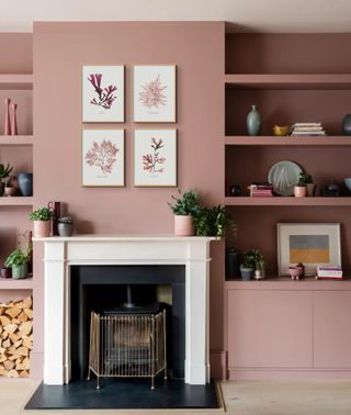 pink living room with open shelving in alcoves of fireplace