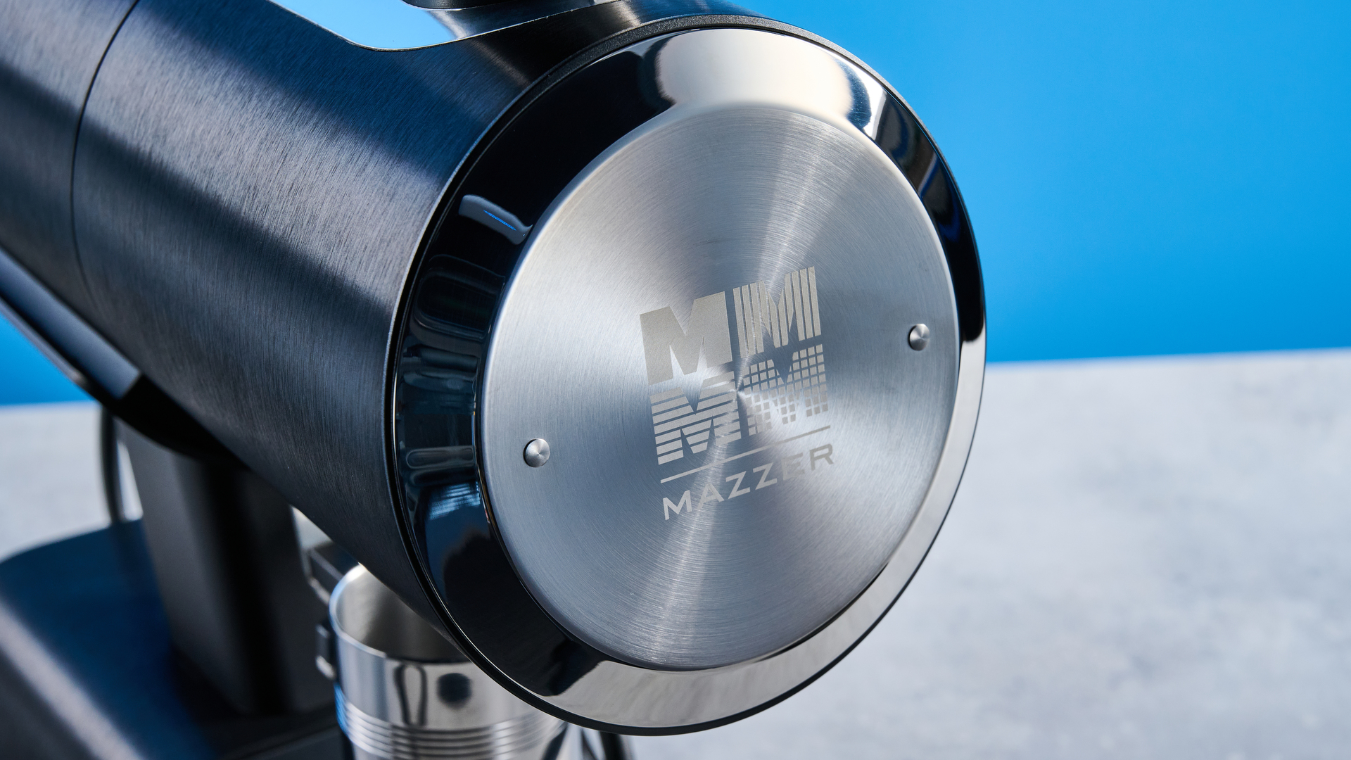 the mazzer philos coffee grinder in black and stainless steel photographed against a tom's guide blue background