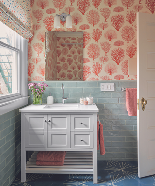 bathroom with seaweed print wallpaper in red with blue tiles and white sink unit and dark blue star pattern flooring
