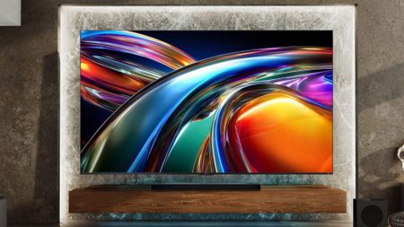 A large, wall-mounted Hisense UR9 RGB Mini-LED TV displaying colorful, abstract imagery in a postmodern living space