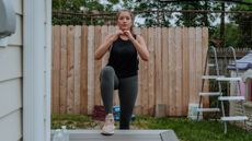 Woman performing step-up exercise in a yard