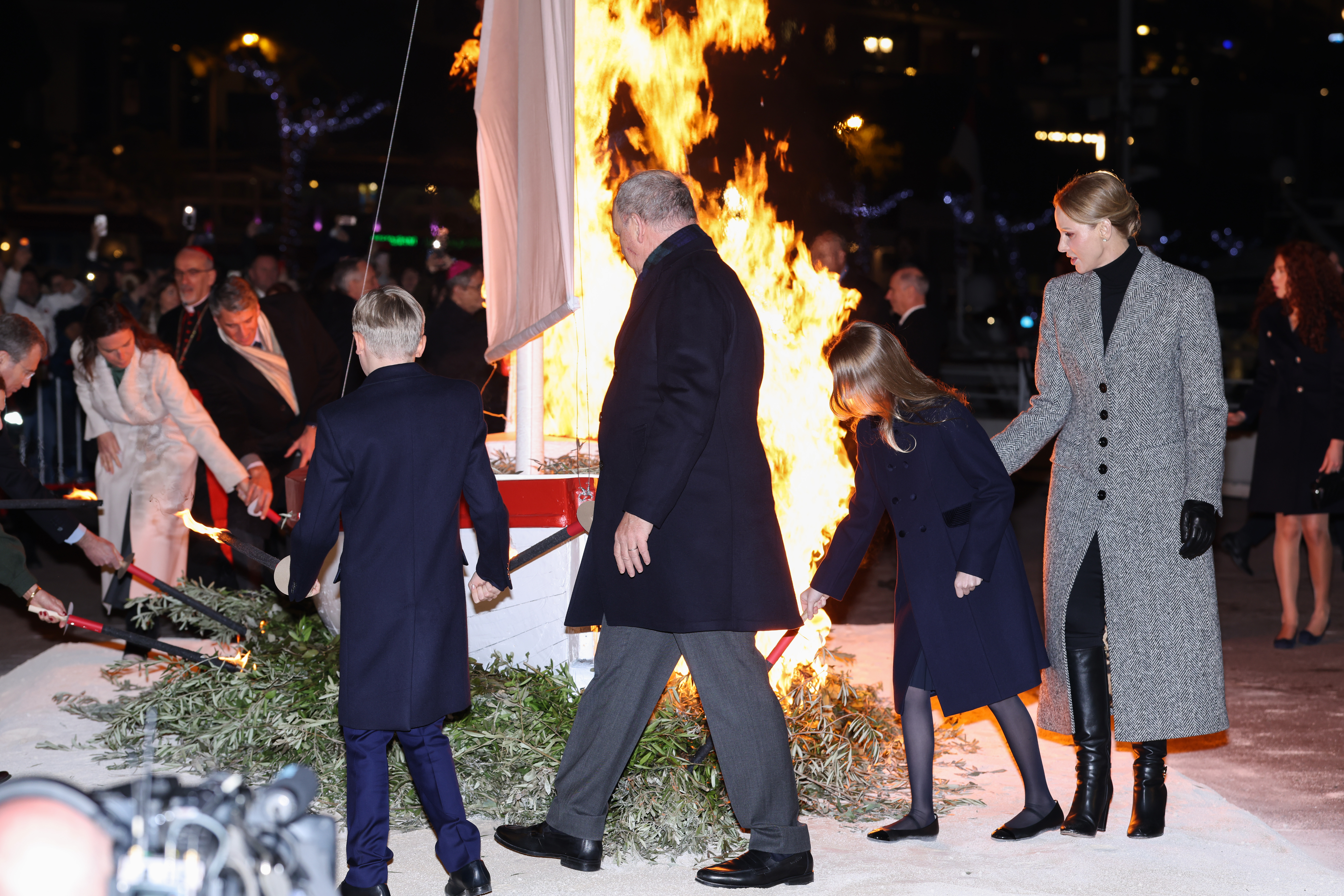 Princess Gabriella, Prince Jacques, Prince Albert and Princess Charlene lighting a ship on fire
