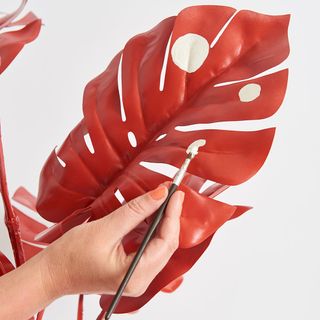 artificial plant leaf with red colour and white spots and paint brush