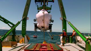 The Pisces IV submersible is lifted on the back deck of the Hawaii Undersea Research Lab ship K-o-K before being deployed into the water.