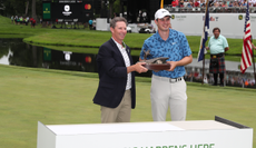 Davis Thompson holds the John Deere Classic trophy