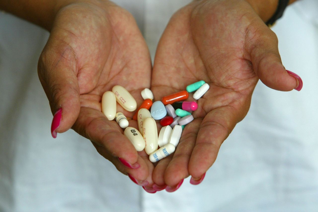 A woman with HIV holds the pills she has to take.