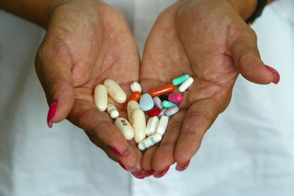 A woman with HIV holds the pills she has to take.