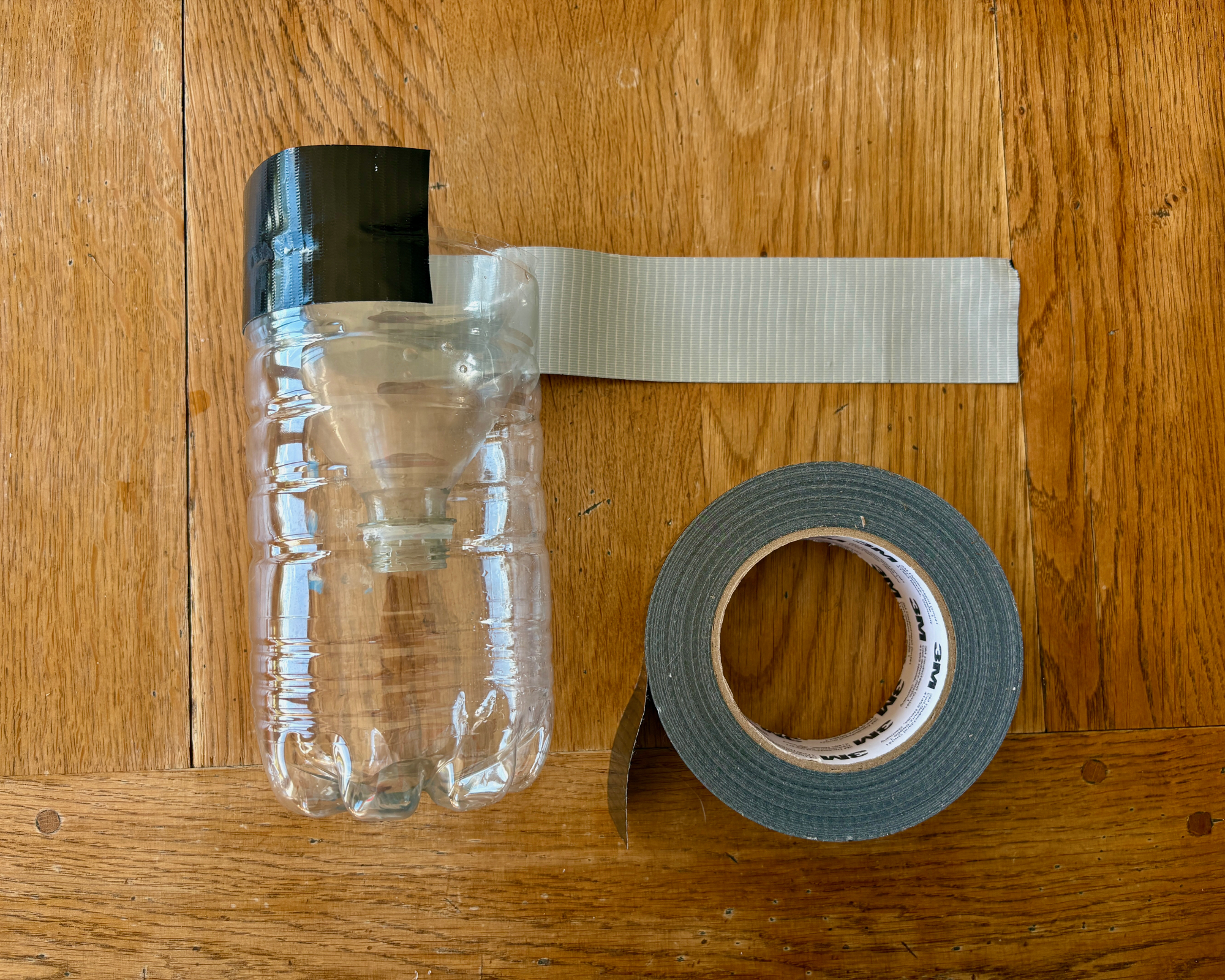 making a mosquito trap by upcycling a plastic bottle, taping the two sections of the bottle togther