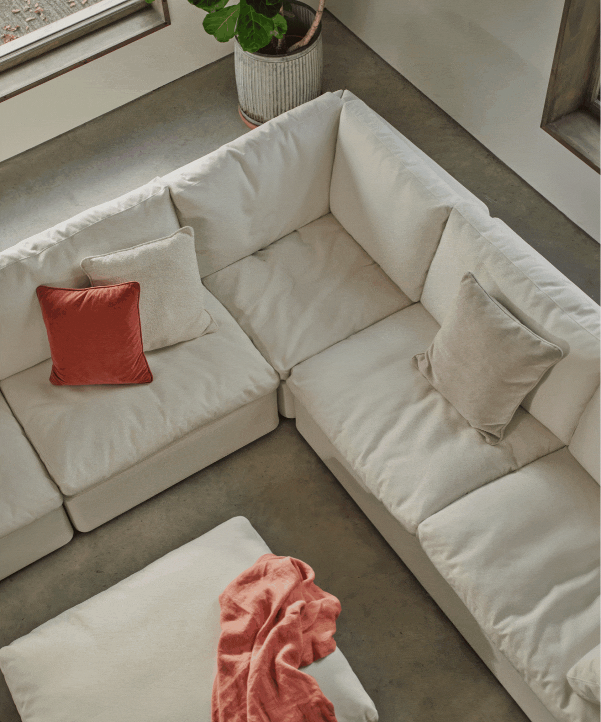 gif of rotating images of swyft&#039;s cloud sofa in white with orange cushions and close-up of a hand squishing the armrest and cushions