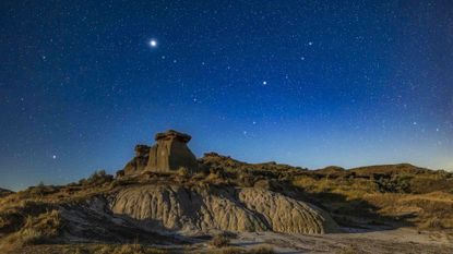Jupiter (bright at left) and Saturn (dimmer at centre) over hoodoo formations at Dinosaur Provincial Park, Alberta, August 29/30, 2021, with the foreground illuminated by moonlight from the rising last quarter Moon. The planets are in or near the constellation of Capricornus framed at centre. This is a blend of two images: a single tracked 1-minute exposure for the sky at f/2.8 and ISO 800 plus a single untracked 3-minute exposure for the ground at f/4 and ISO 800, both with the Canon 15-35mm RF lens at 29mm and Canon R6 camera on the Star Adventurer Mini tracker. I added a mild Orton effect with Luminar AI. Long Exposure Noise Reduction applied to the ground image in camera. (Photo by: Alan Dyer/VW Pics/Universal Images Group via Getty Images)