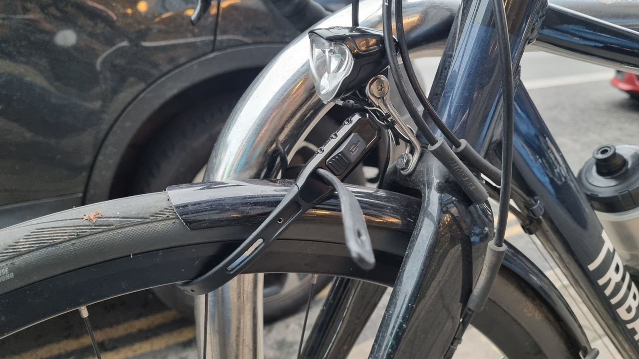 A Hiplok Z Lok Combo securing the front wheel of a road bike to a Sheffield stand