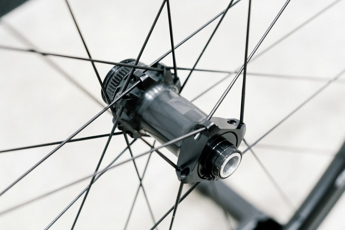 An aero road wheel stands against a white wall