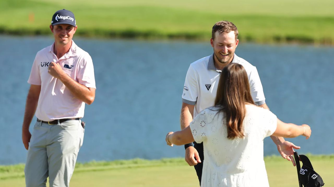 JT Poston looks on as Lee Hodges is hugged by his partner