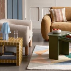 A living room with Habitat's Drape boucle armchair and a tiled side table next to it