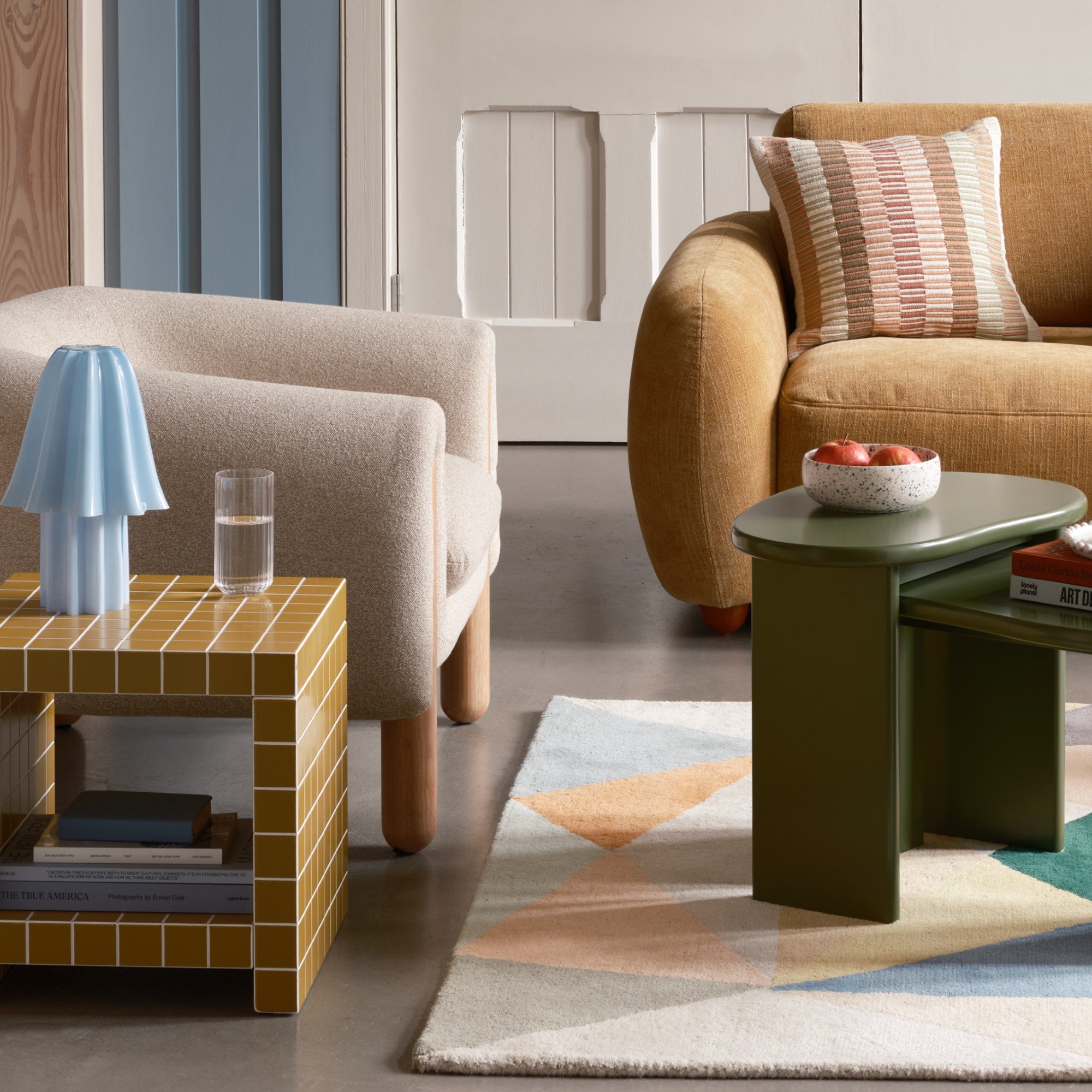 A living room with Habitat's Drape boucle armchair and a tiled side table next to it
