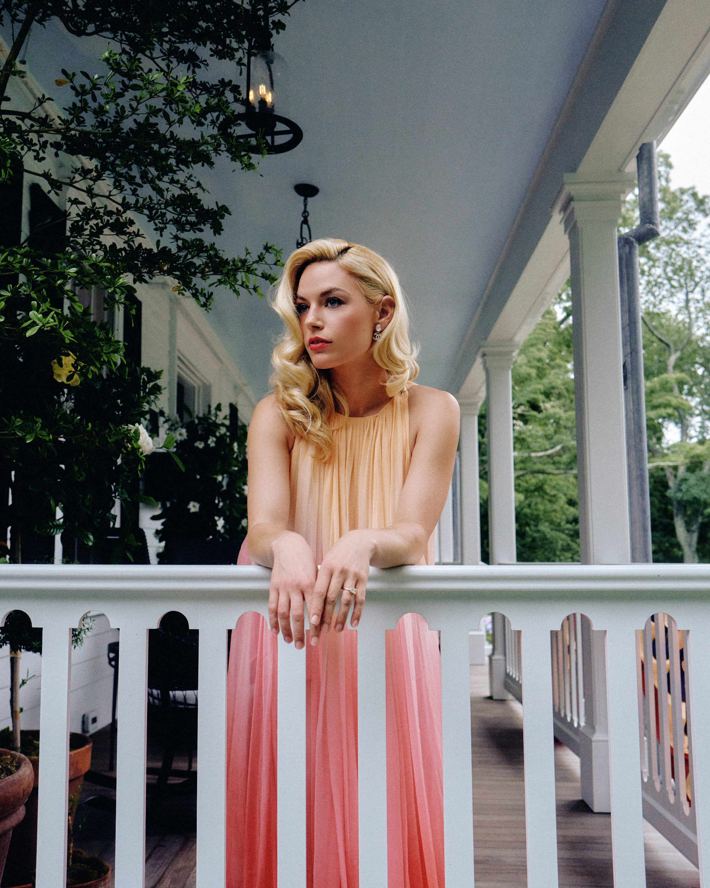 Ashe poses on a balcony wearing a Chanel dress