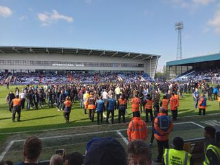 Oldham fans spill on to the pitch