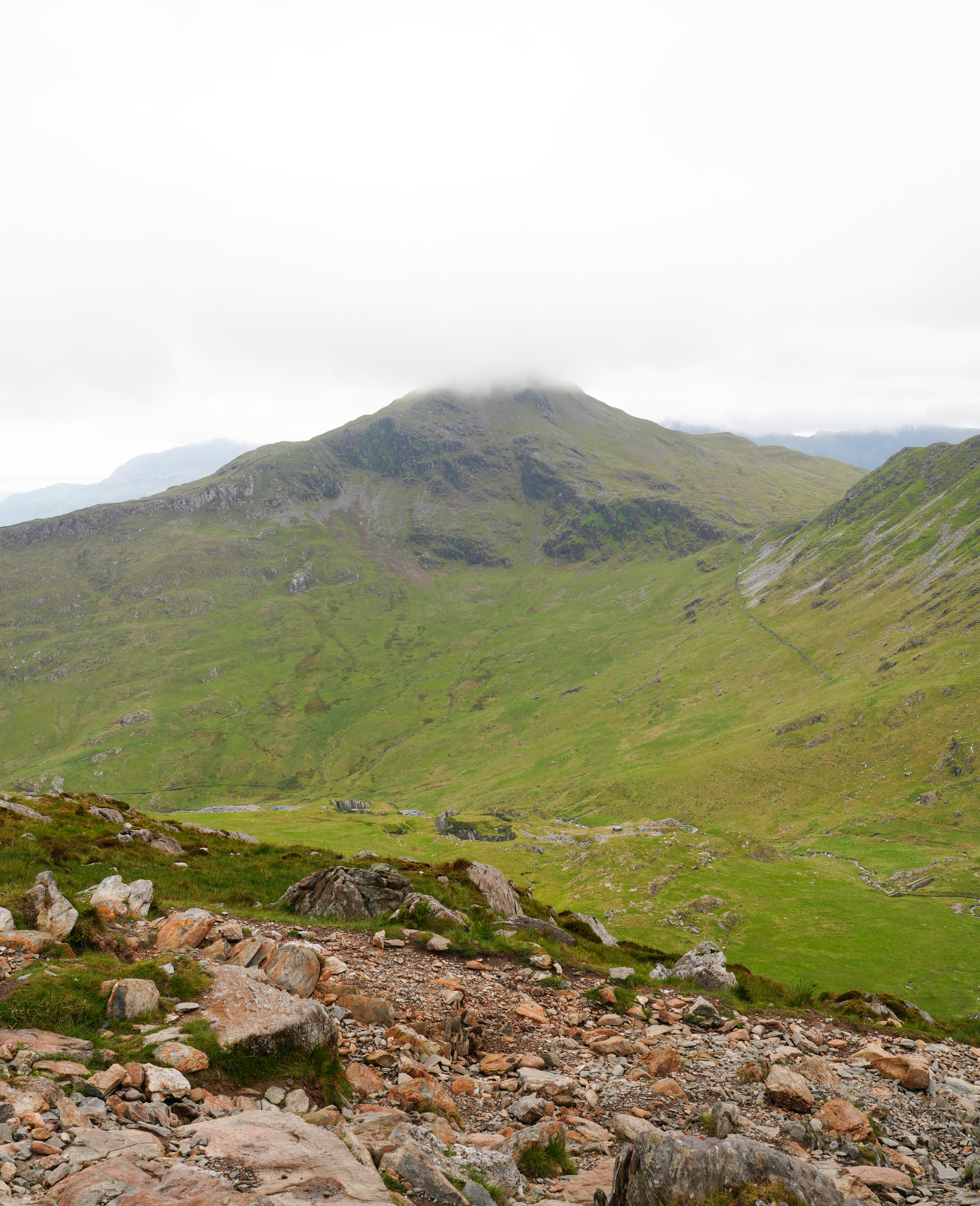A photo of a mountain, rimmed with cloud