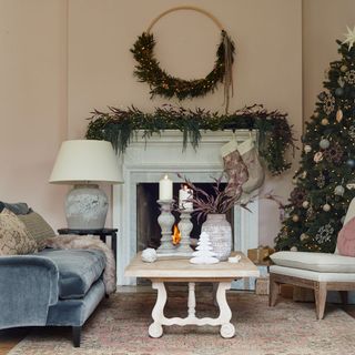 White living room with decorated Christmas tree and decorated mantelpiece