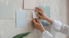 Somone sticking paint samples to a plaster wall