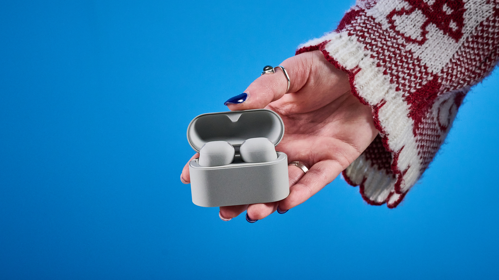 Sony WF-1000XM6 earbuds photographed in front of a blue background