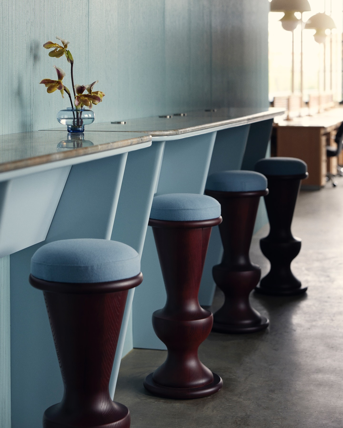 Image of a light blue bar with light blue and dark cherry wood bar stools.