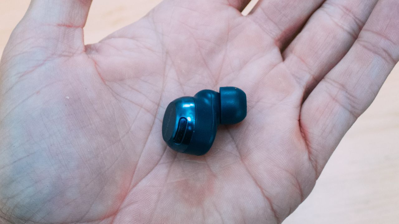 A Technics eah-az100 earbud in the palm of a hand