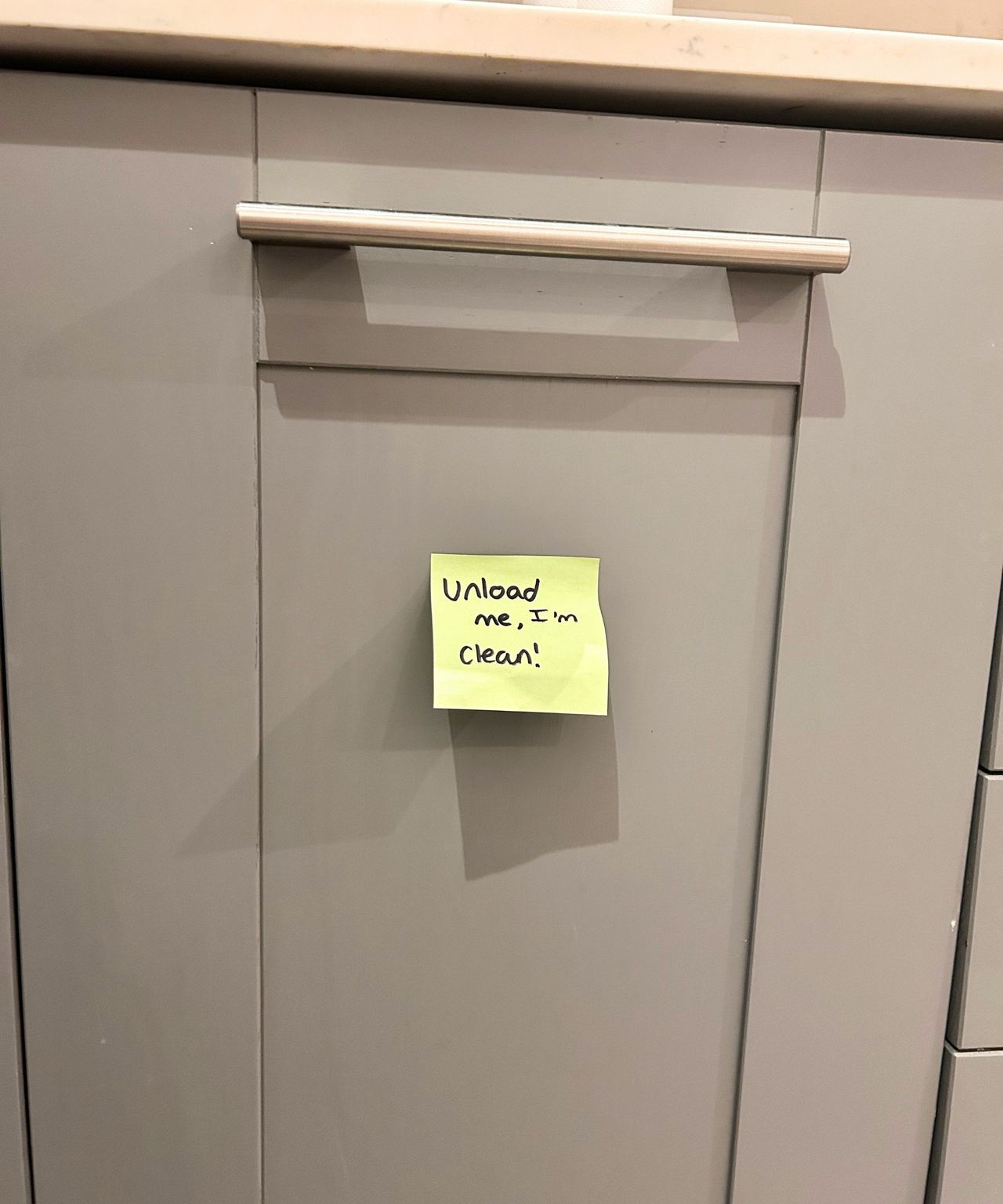 Grey kitchen cabinet with Post-it note on it