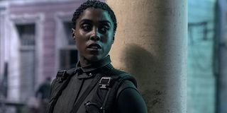 Nomi (Lashana Lynch) stands against a pillar in a scene from 'No Time To Die'