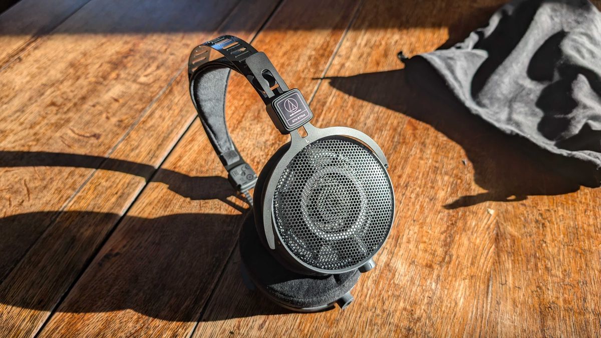 A pair of Audio-Technica ATH-R70XA headphones on a brightly lit wooden table