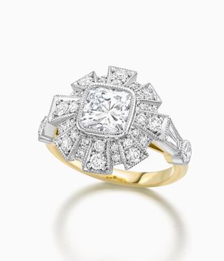 Jessica McCormack Ring with a gold band an a large halo diamond on top.