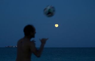 Rafael Fonseca plays soccer beneath a supermoon on Aug. 10, 2014, in Miami Beach, Florida.