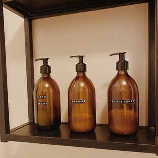 Aura 500ml Amber Glass Bottles with Black Pumps, labelled in Annie's bathroom