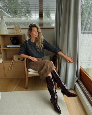 Anouk wear suede skirt with grey knit jumper and knee high boots.