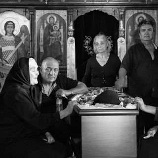 Mourners by a coffin in a Greek church