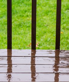 A rainy wooden deck and railings 