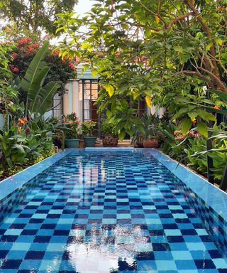 Swimming pool looking to house with blue checkered tiles on floor