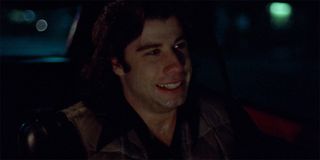 John Travolta as Billy Nolan driving a car in Carrie