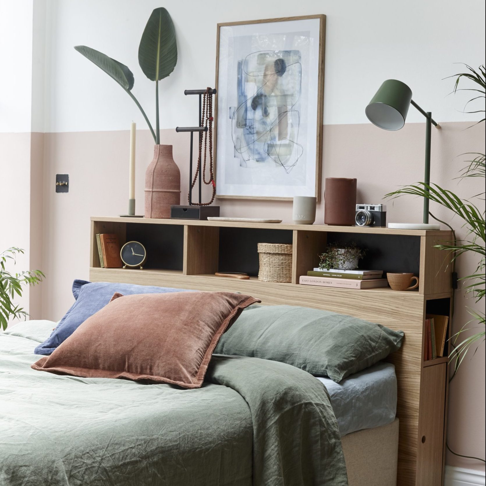 bedroom with pink and white wall grey bed and wooden shelves