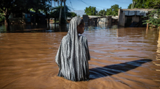 A woman wades through flood waters in Garissa, Kenya