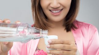 Is mouthwash necessary? image shows woman using mouthwash
