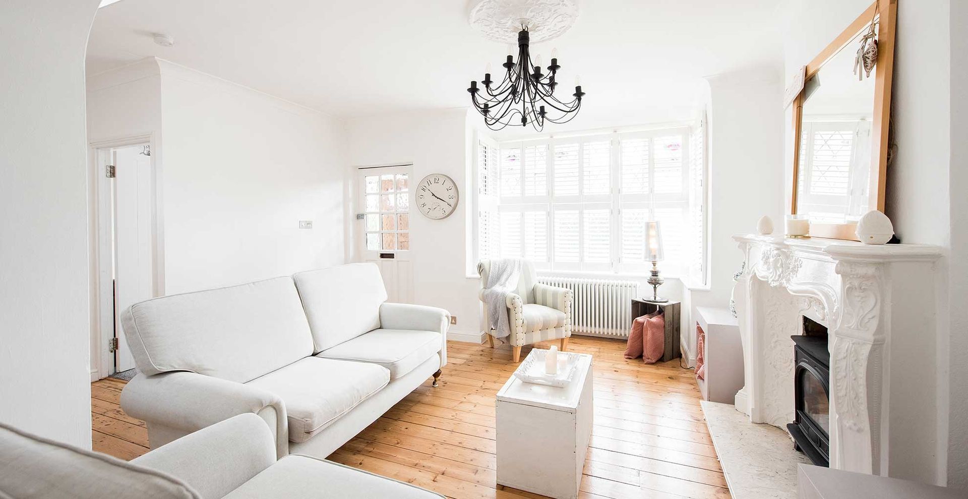 white living room with doors painted the same colour as walls to make the space look bigger