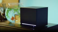 Valve Steam Machine on a desktop with a goldfish swimming in a tank behind it