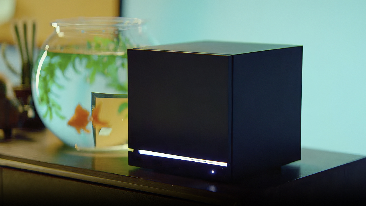 Valve Steam Machine on a desktop with a goldfish swimming in a tank behind it