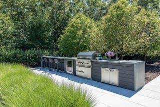 a long outdoor kitchen with a grill and seating