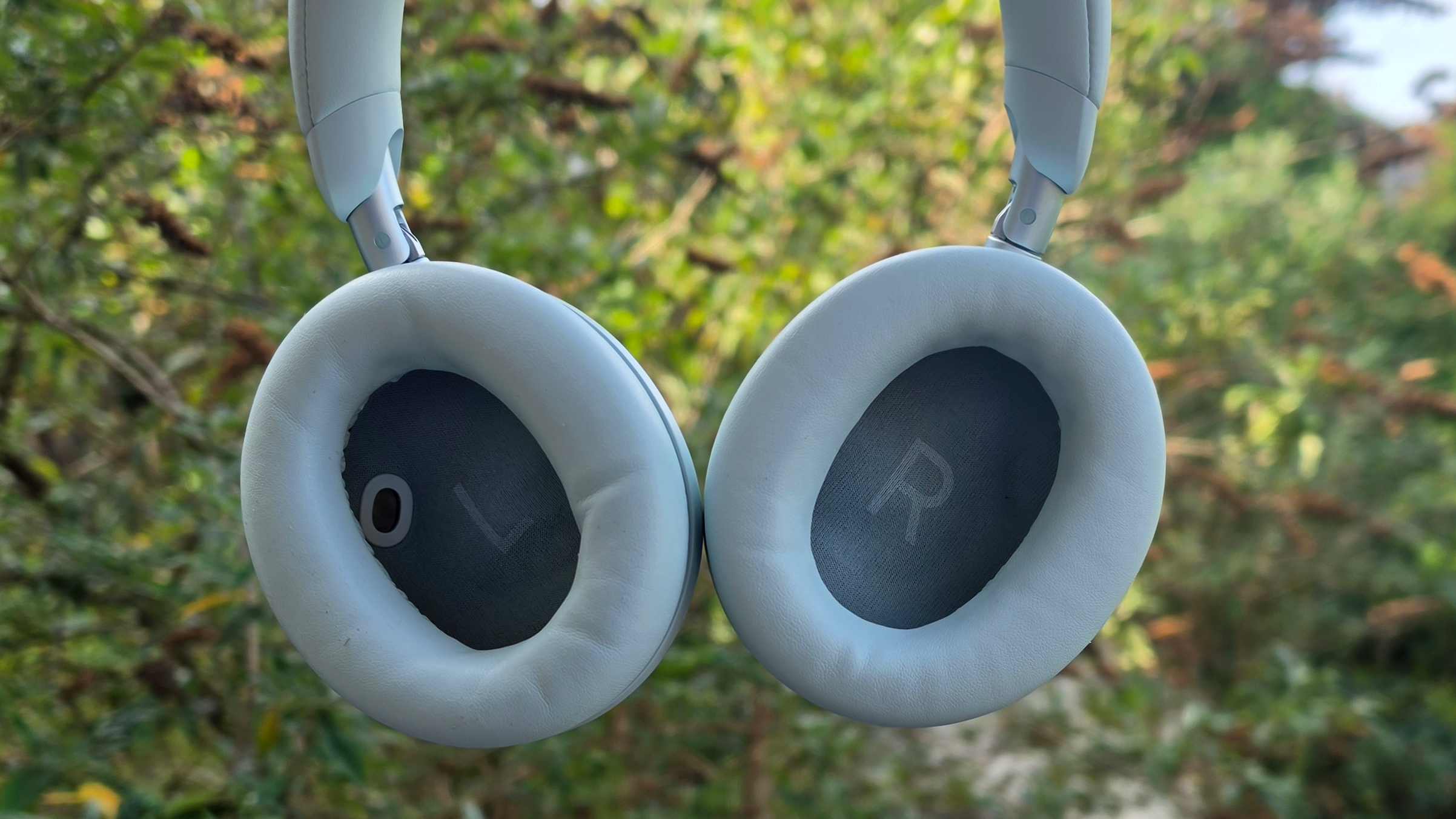 The Soundcore Space 2 in front of a green bush.