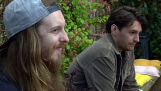 Ryan Stocks and Mack sit on a bench in Emmerdale. 