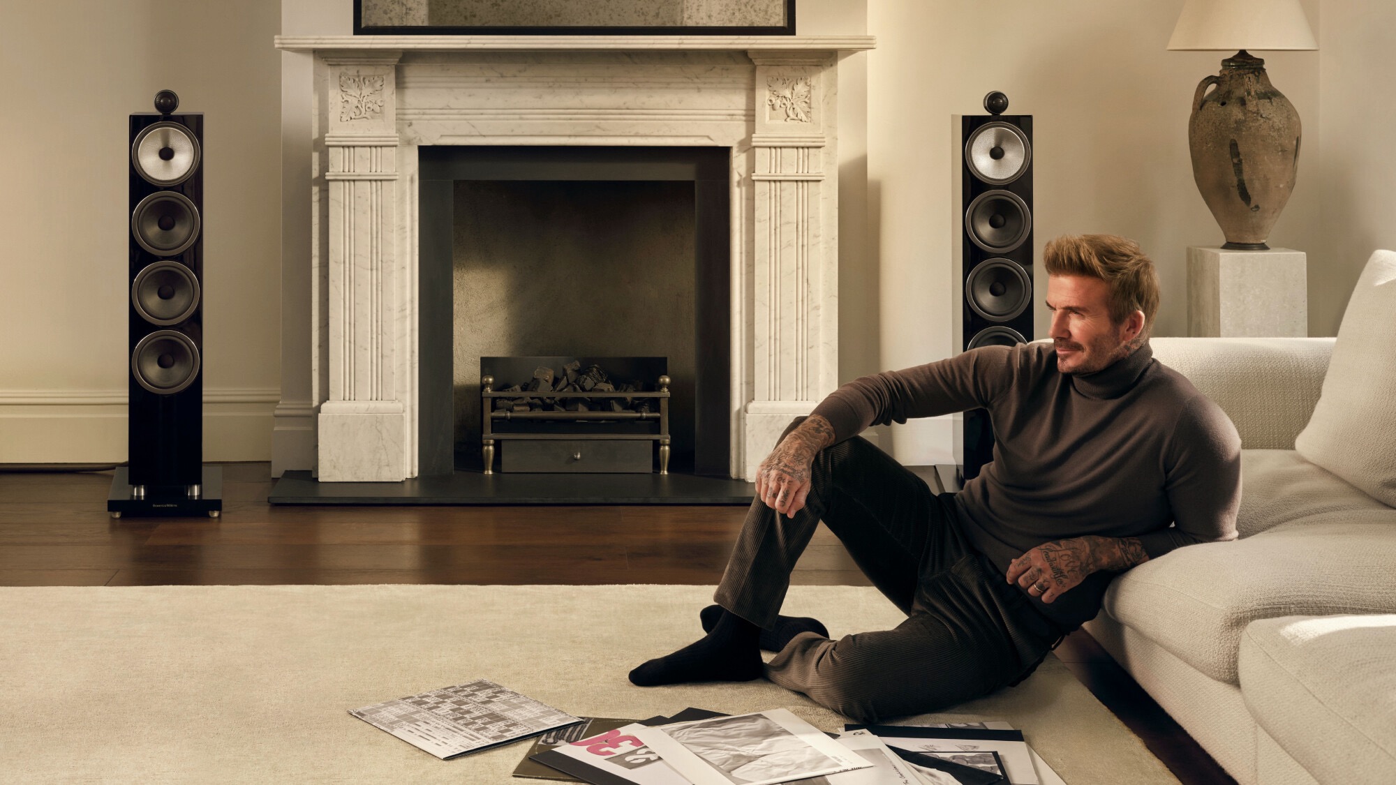 David Beckham relaxing in front of a pair of Bowers &amp;amp; Wilkins 702 S3 speakers in a lounge.